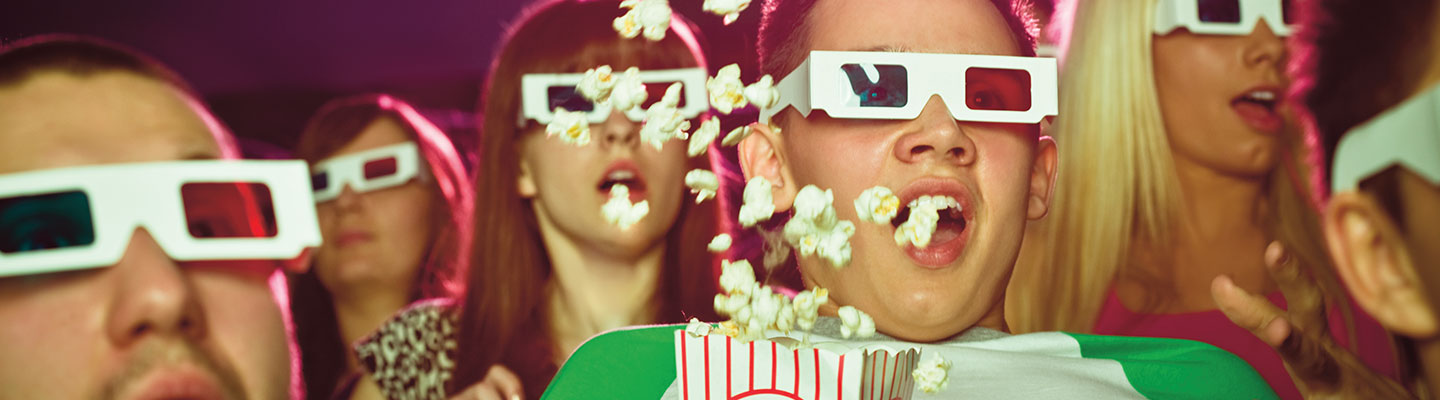 People wearing 3D glasses at a movie looking startled.