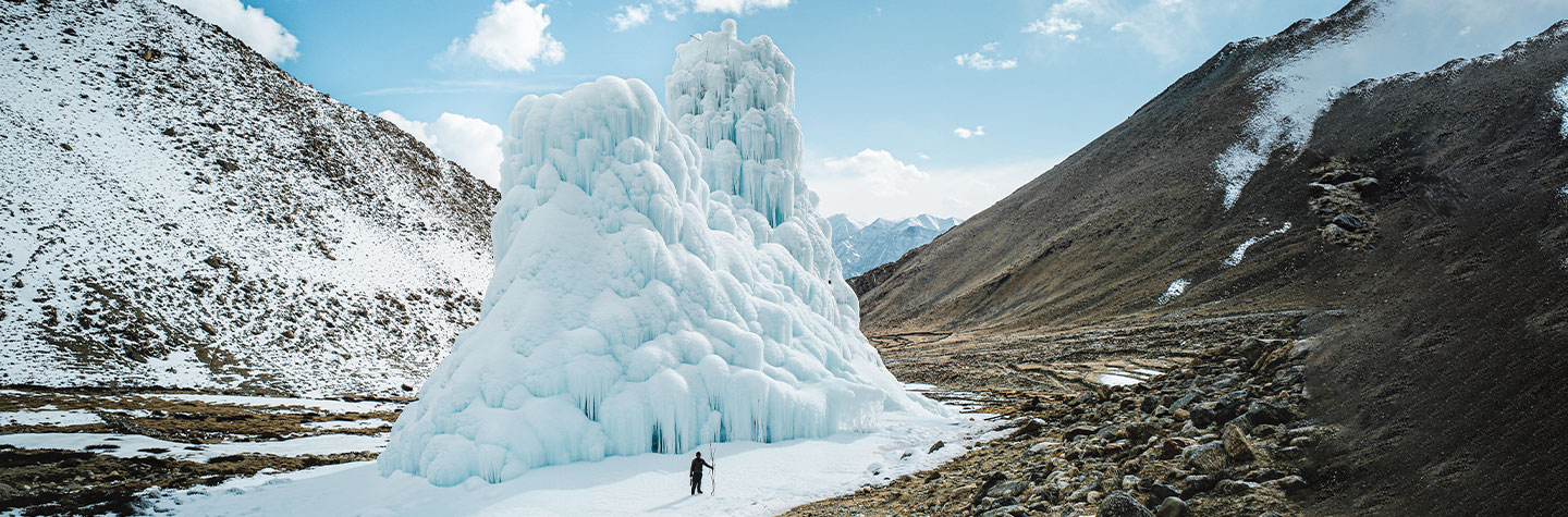 Person standing in front of a giant ice mound