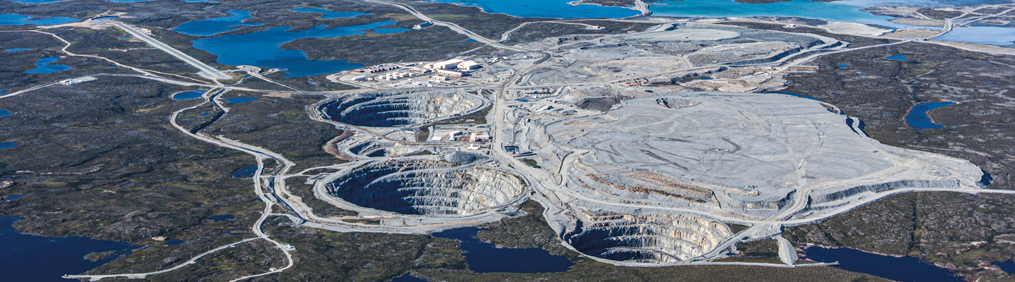 A landscape with large mines and lakes in the background