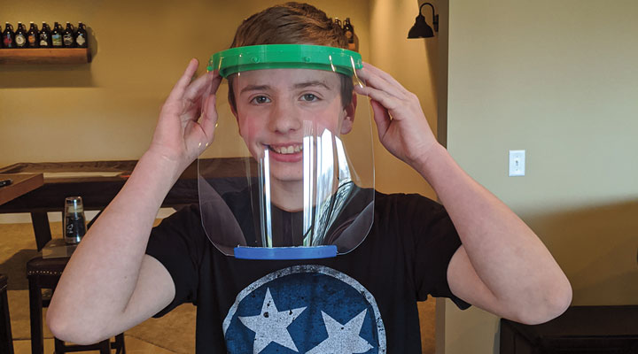 A boy wearing a face shield