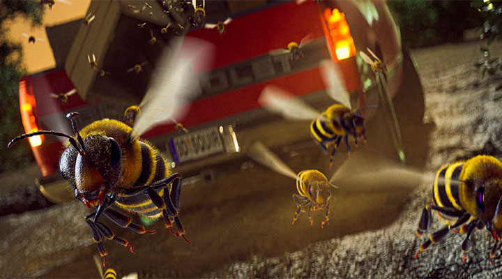 An up-close image of honey bees flying out of the back of a pick-up truck